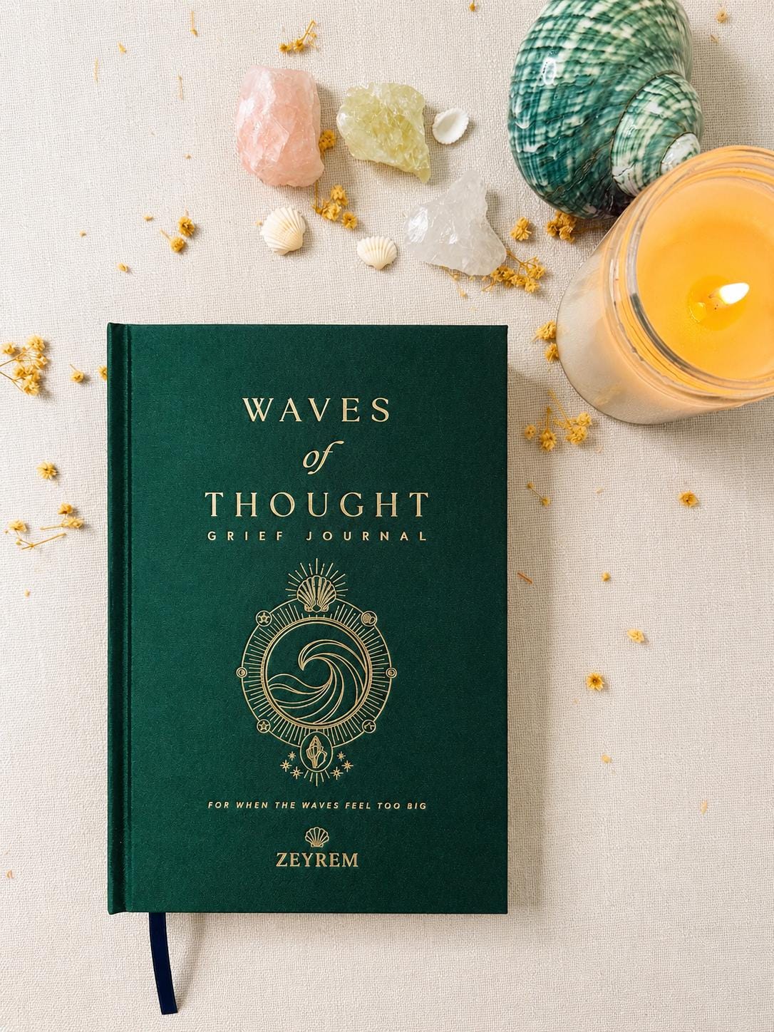 Back cover of the Waves of Thought grief journal in forest green linen with the Zeyrem logo in gold foil