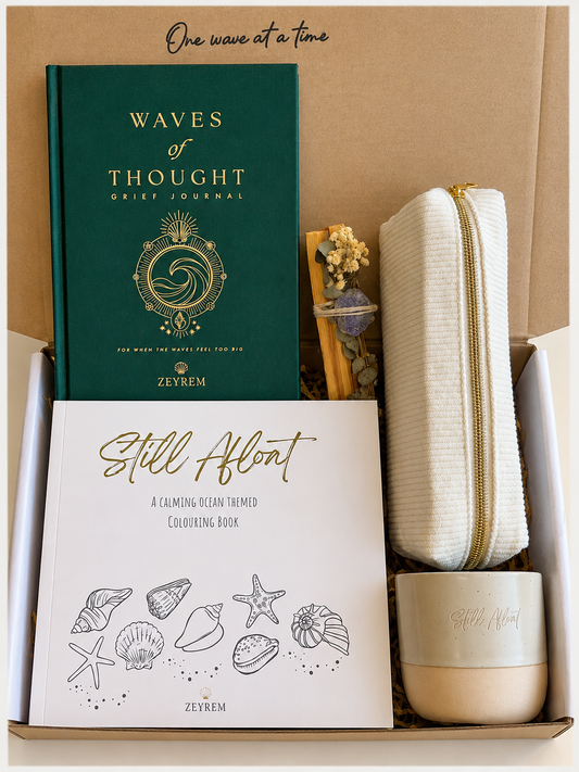 Grief care package open in a Zeyrem box, with the Waves of Thought journal, Still Afloat colouring book, corduroy pencil pouch, ceramic cup and a smudge bundle with dried flowers