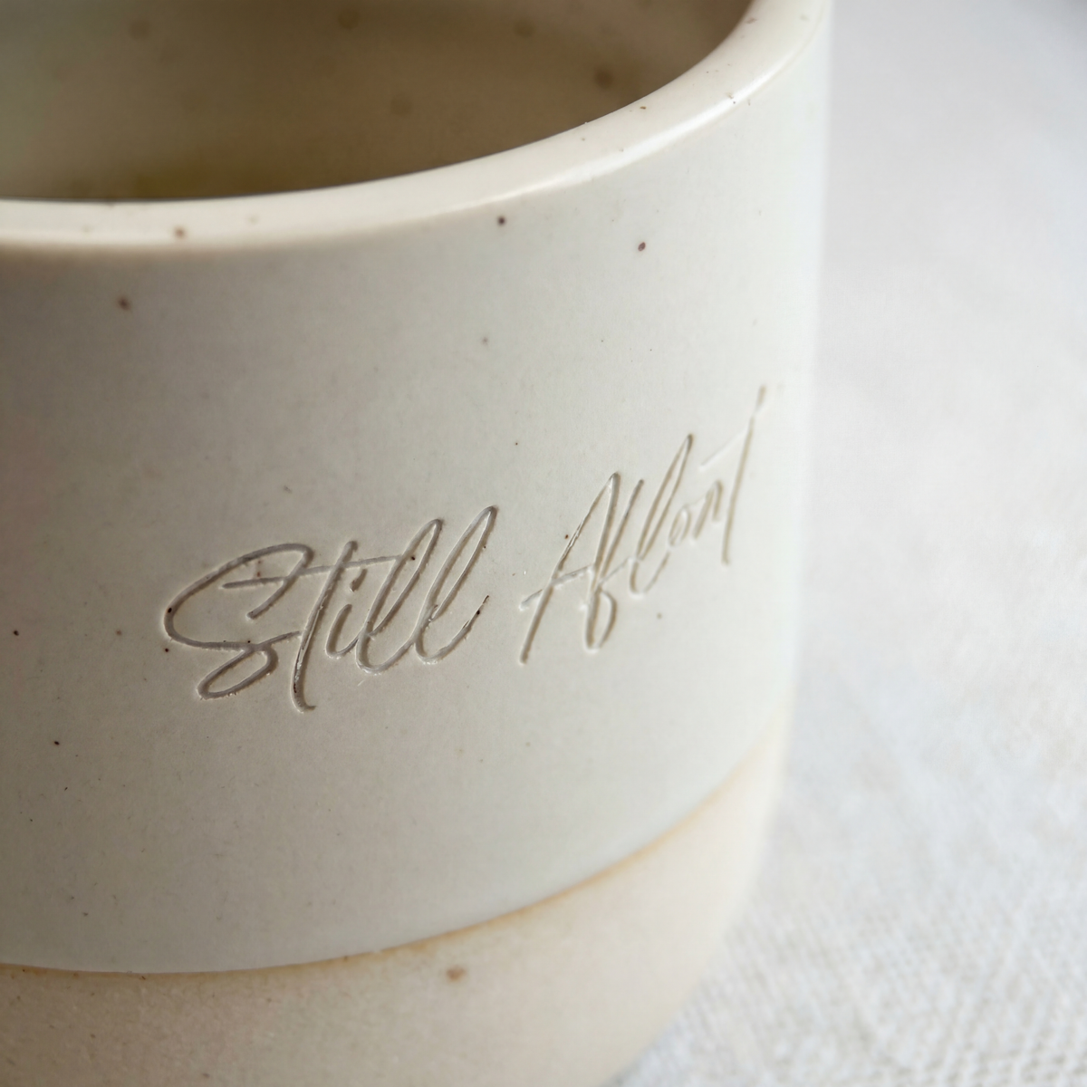 Close up of the Still Afloat ceramic cup with engraved lettering, included in the One Wave at a Time grief care package